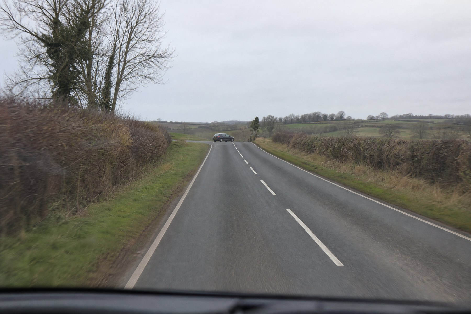 car_pulling_onto_road_in_distance